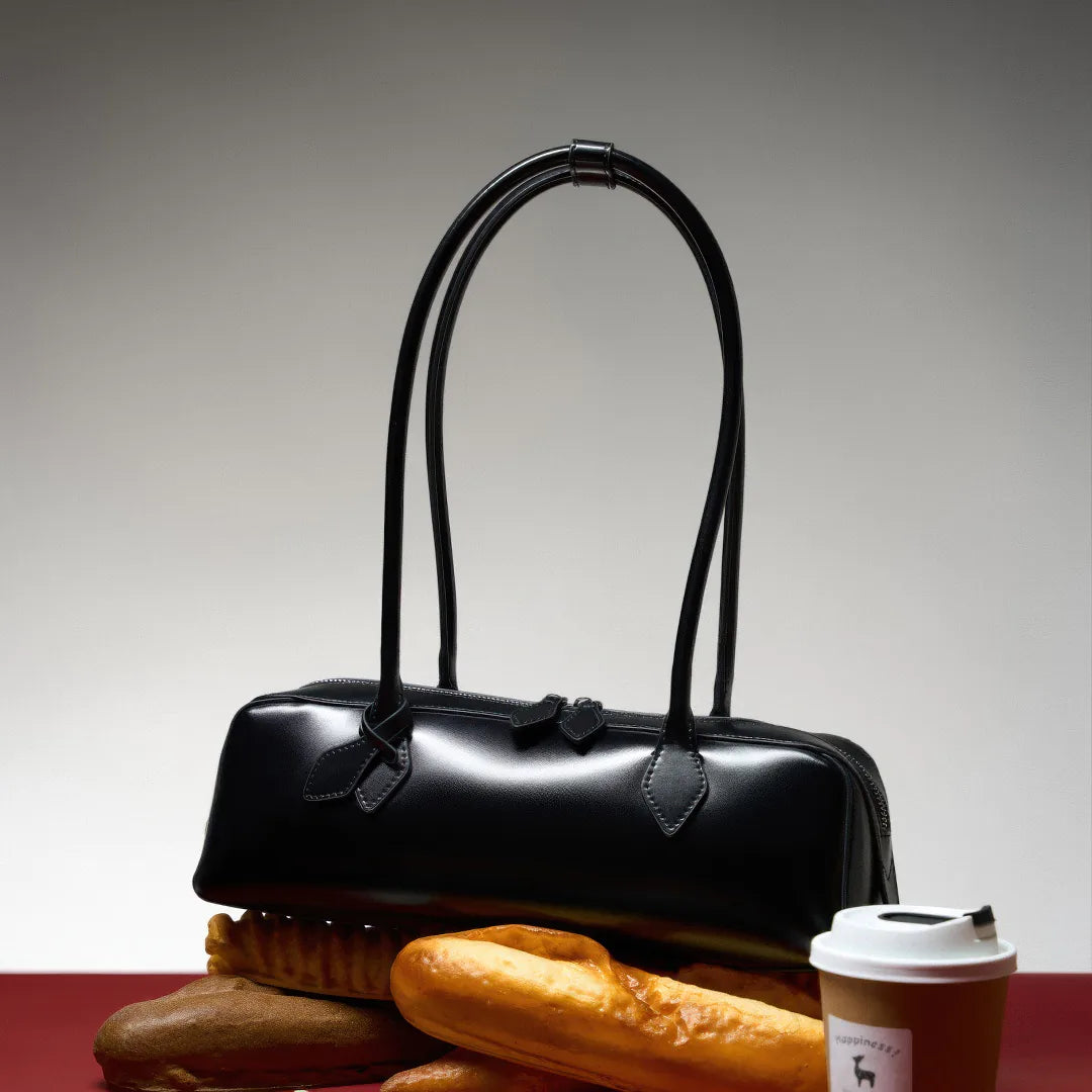 Black handbag with pastries and a coffee cup on a gradient background #Color_Black