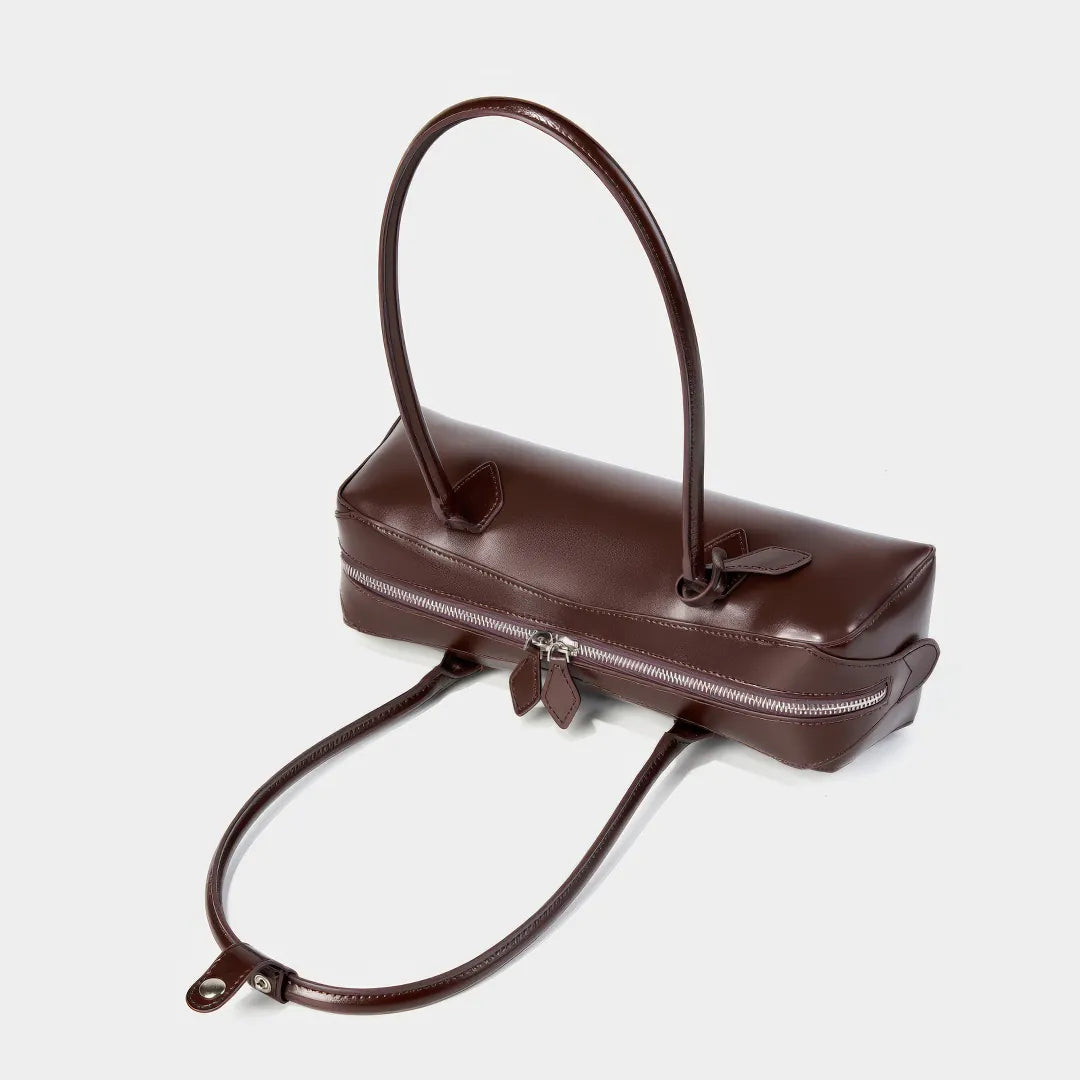 Brown leather handbag with a shoulder strap on a light gray background #Color_Brown