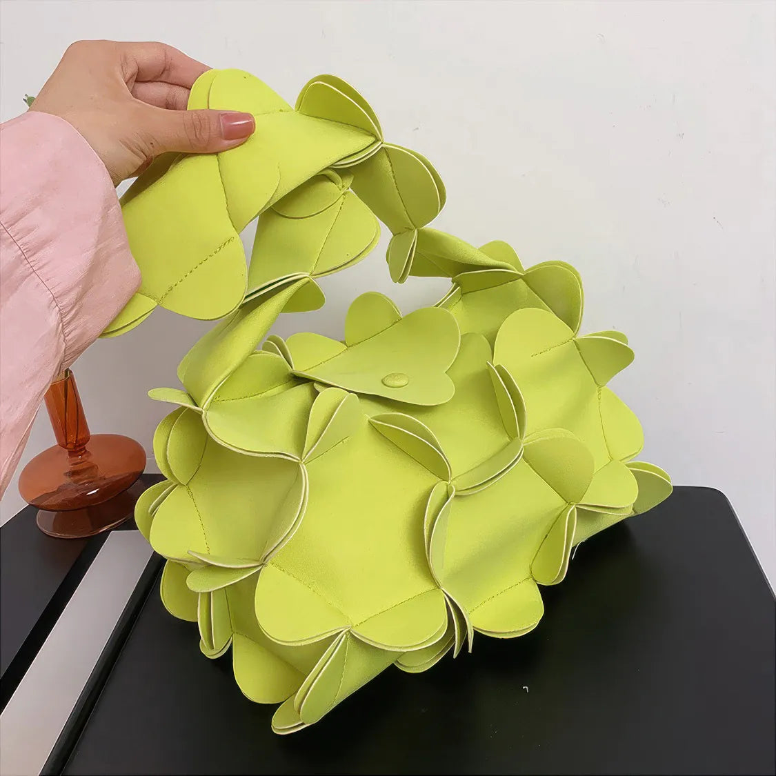 Hand holding a lime green floral-patterned handbag on a white background. #Addtl