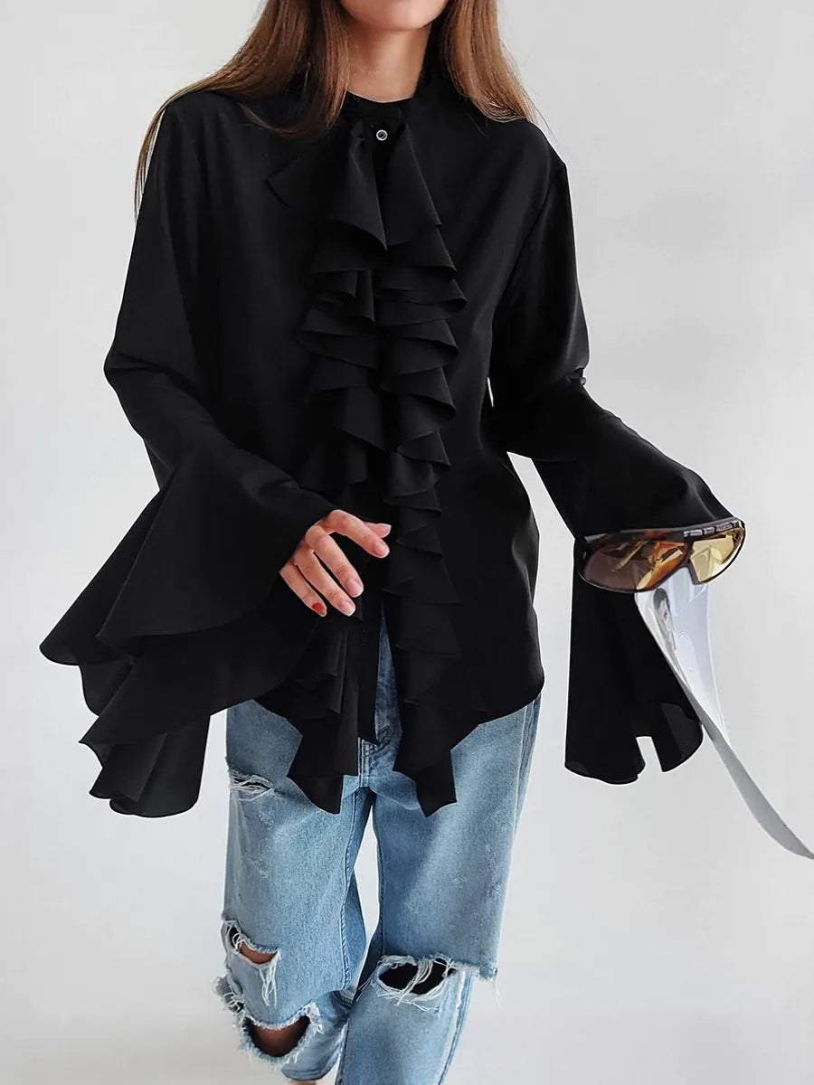 Person wearing a black ruffled blouse with rolled-up sleeves and ripped jeans on a white background  #Color_Black