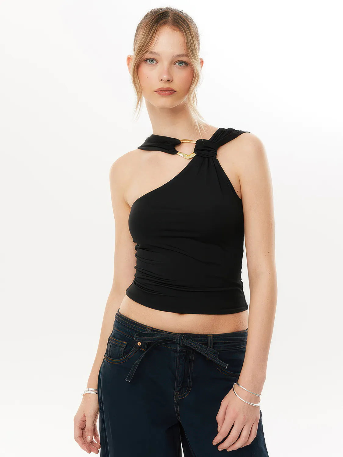Woman wearing a black halter top and dark jeans on a white background #Color_Black