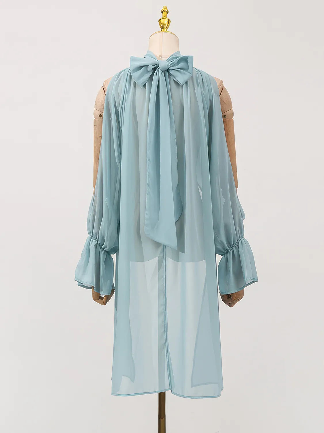 Light blue dress with a large bow on a mannequin against a white background. #Color_Blue
