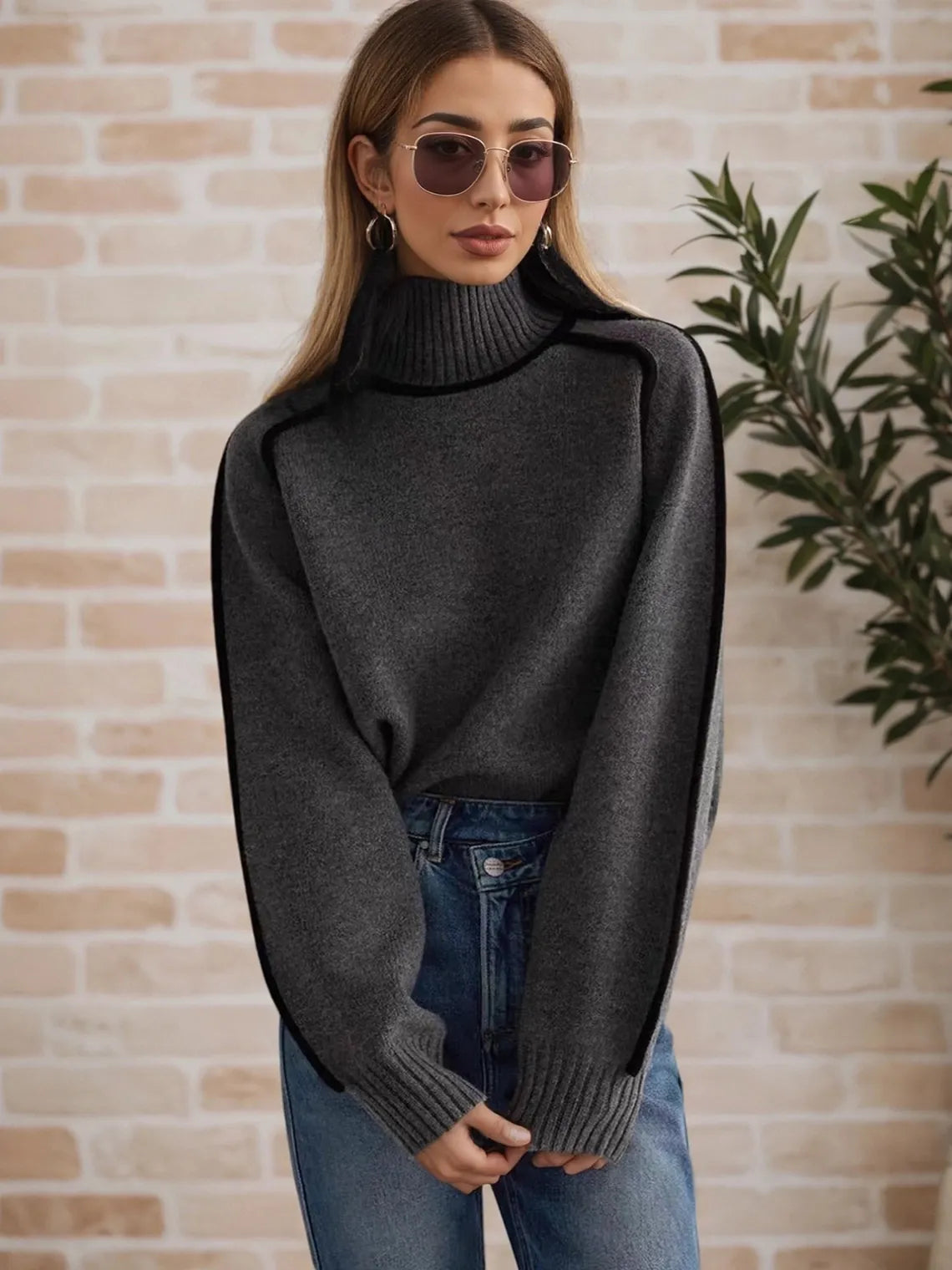 Woman wearing a dark gray turtleneck sweater and sunglasses against a brick wall. #Color_DimGray