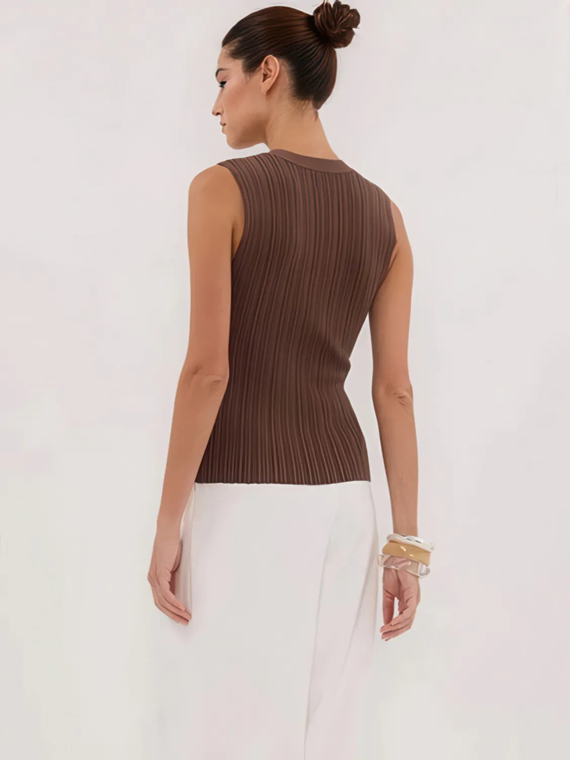 Woman wearing a brown ribbed sleeveless top against a white background. #Color_Coffee