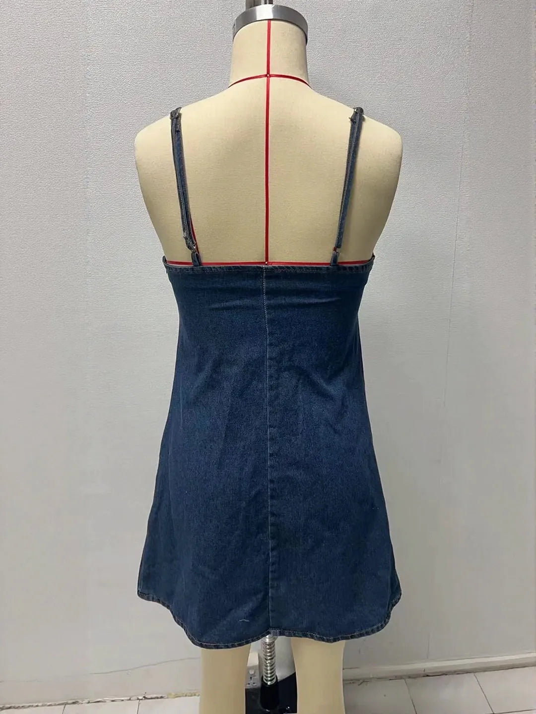 Blue denim dress on a mannequin against a gray background. #Color_Blue