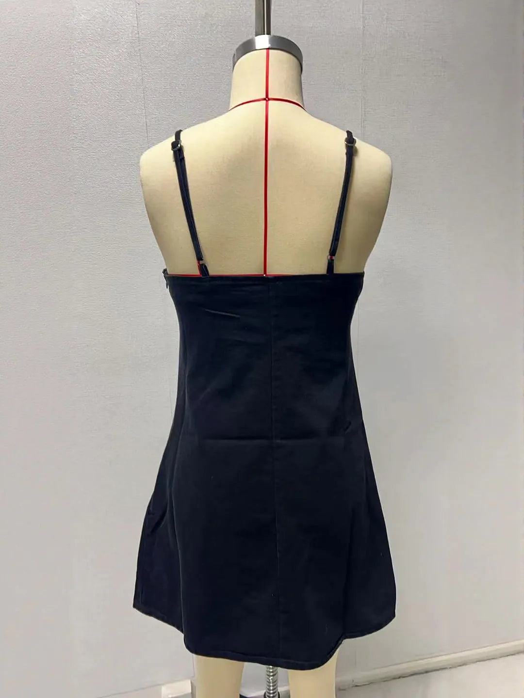 Black dress on a mannequin with a plain background. #Color_Black