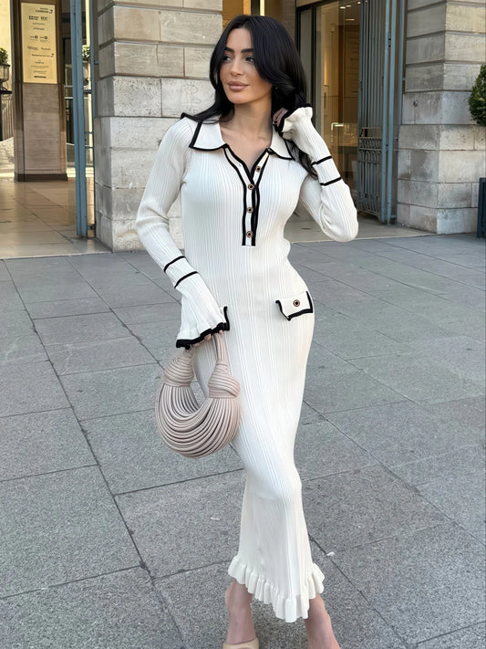 Woman in a white dress with black accents standing on a city street. #Color_White
