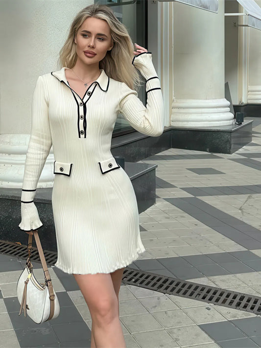 Woman in a white dress with black accents standing on a city street. #Color_White