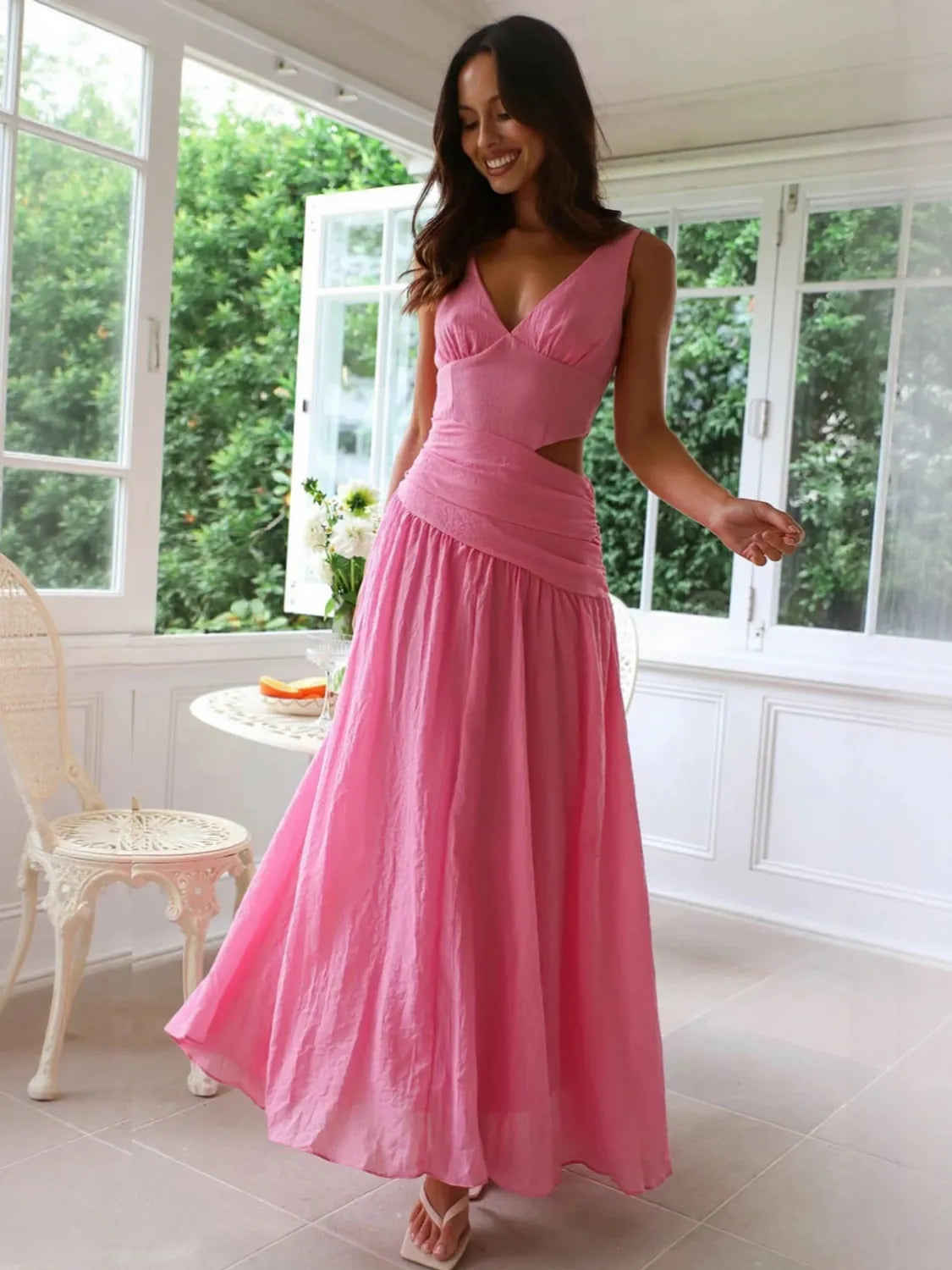 Woman wearing a pink dress in a bright room with large windows. #Color_HotPink