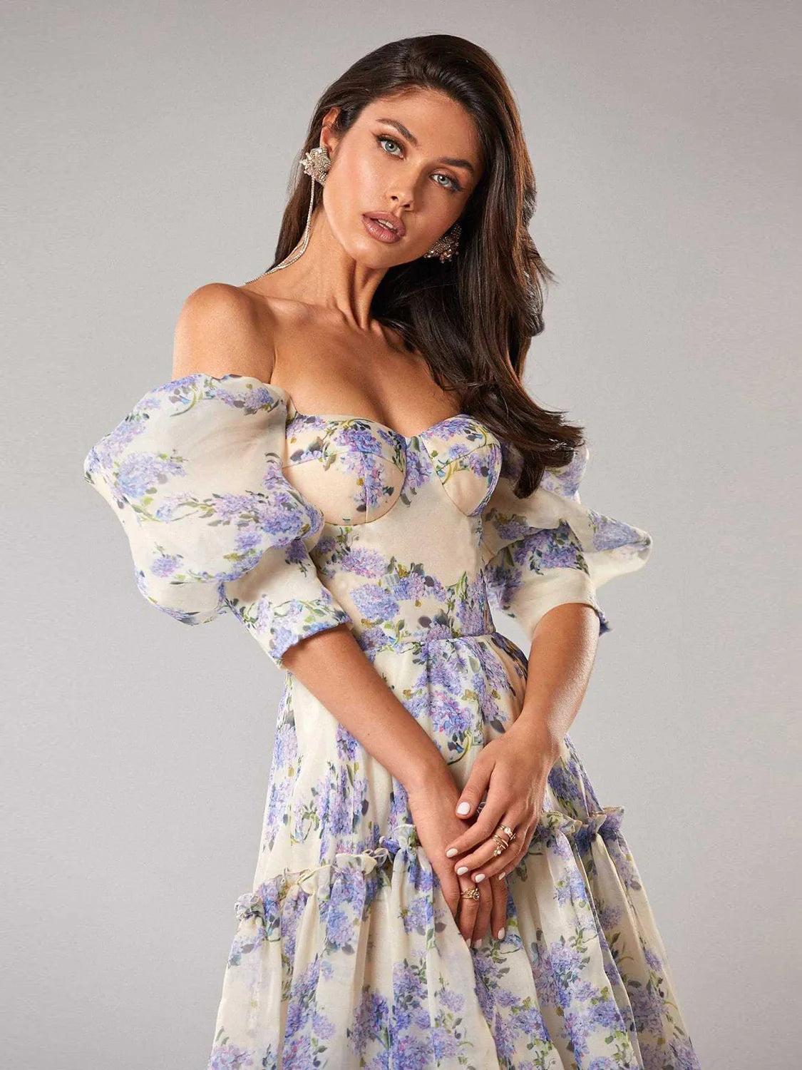 Woman wearing a floral off-shoulder dress against a gray background. #Color_Blue