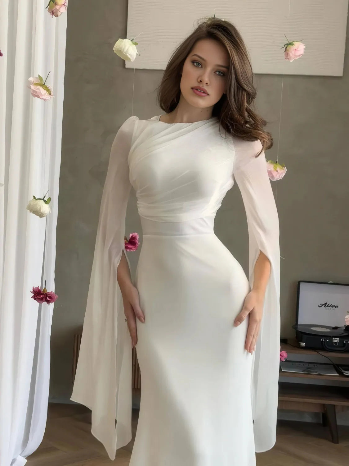 Woman wearing a white dress with long sleeves in an indoor setting. #Color_White