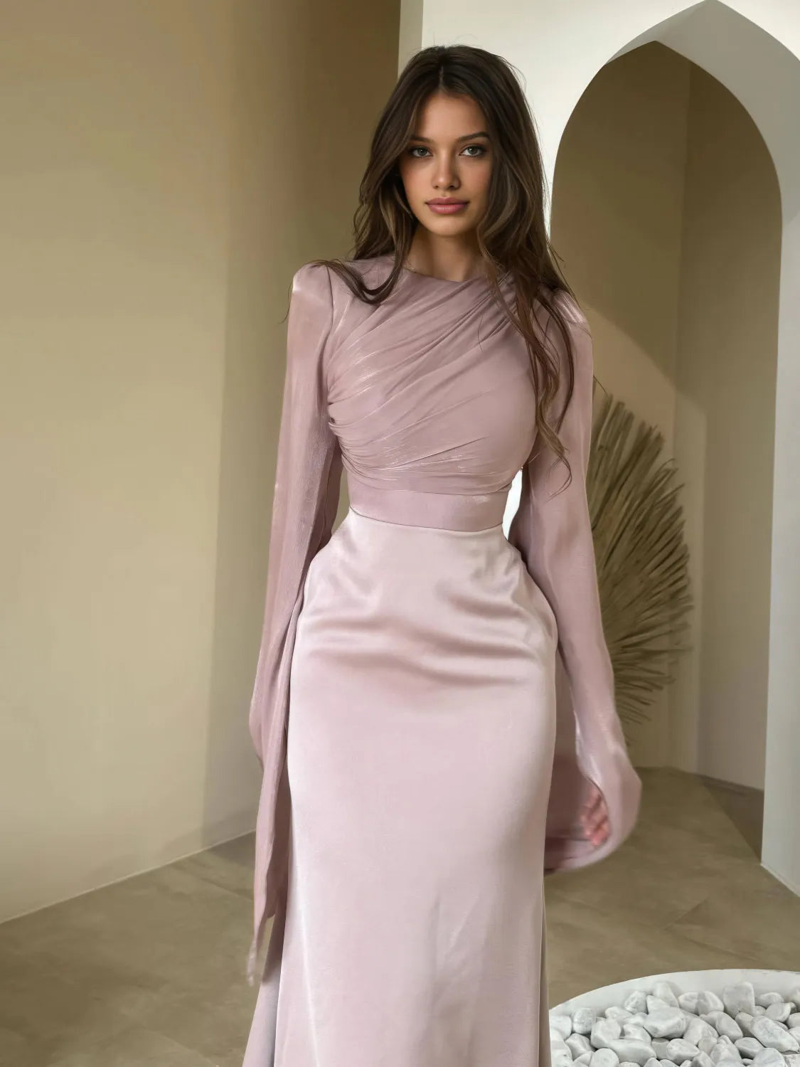 Woman wearing a pink dress with long sleeves in an indoor setting. #Color_Pink