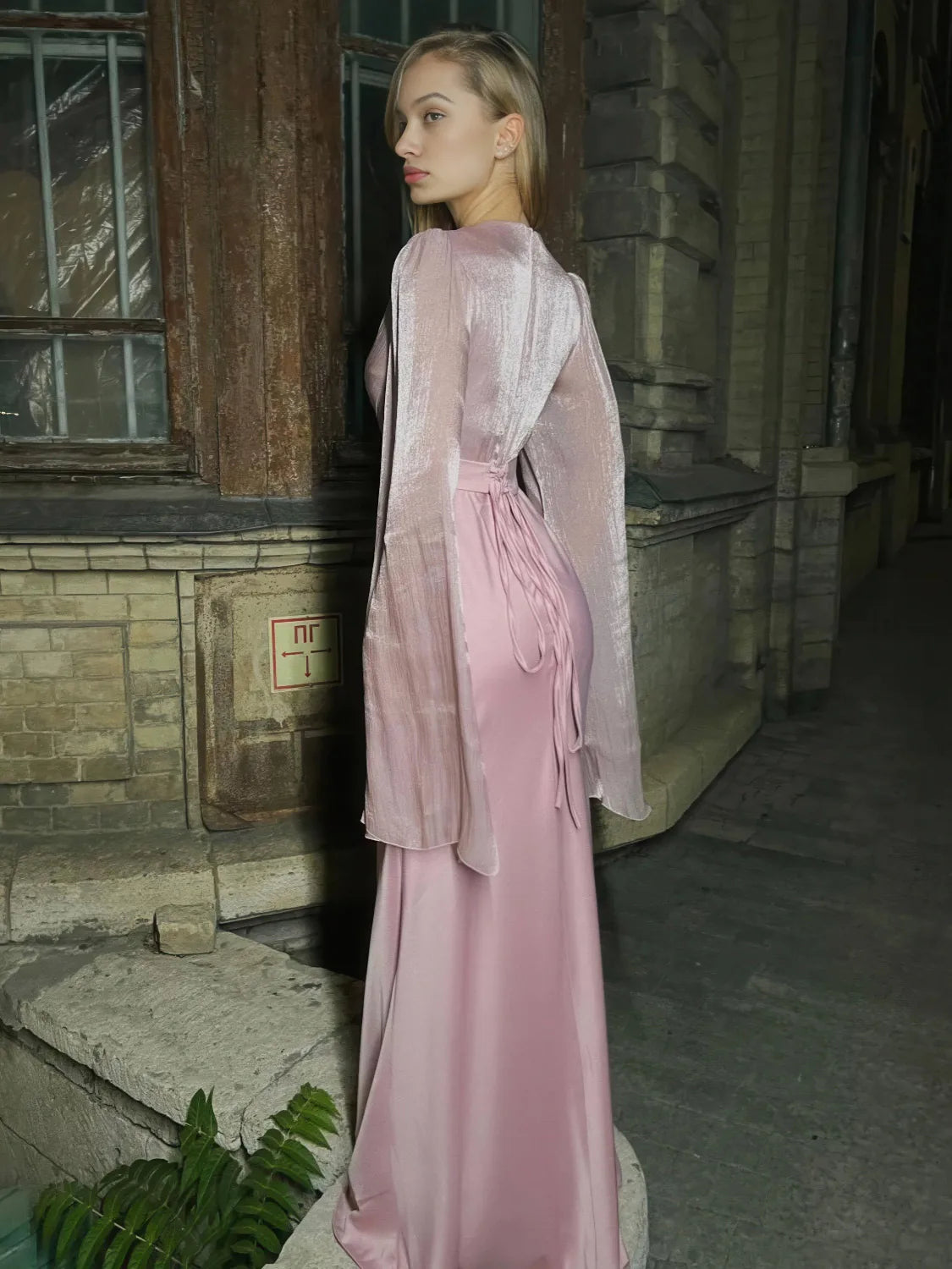 Woman in a pink dress standing in front of an old building. #Color_Pink