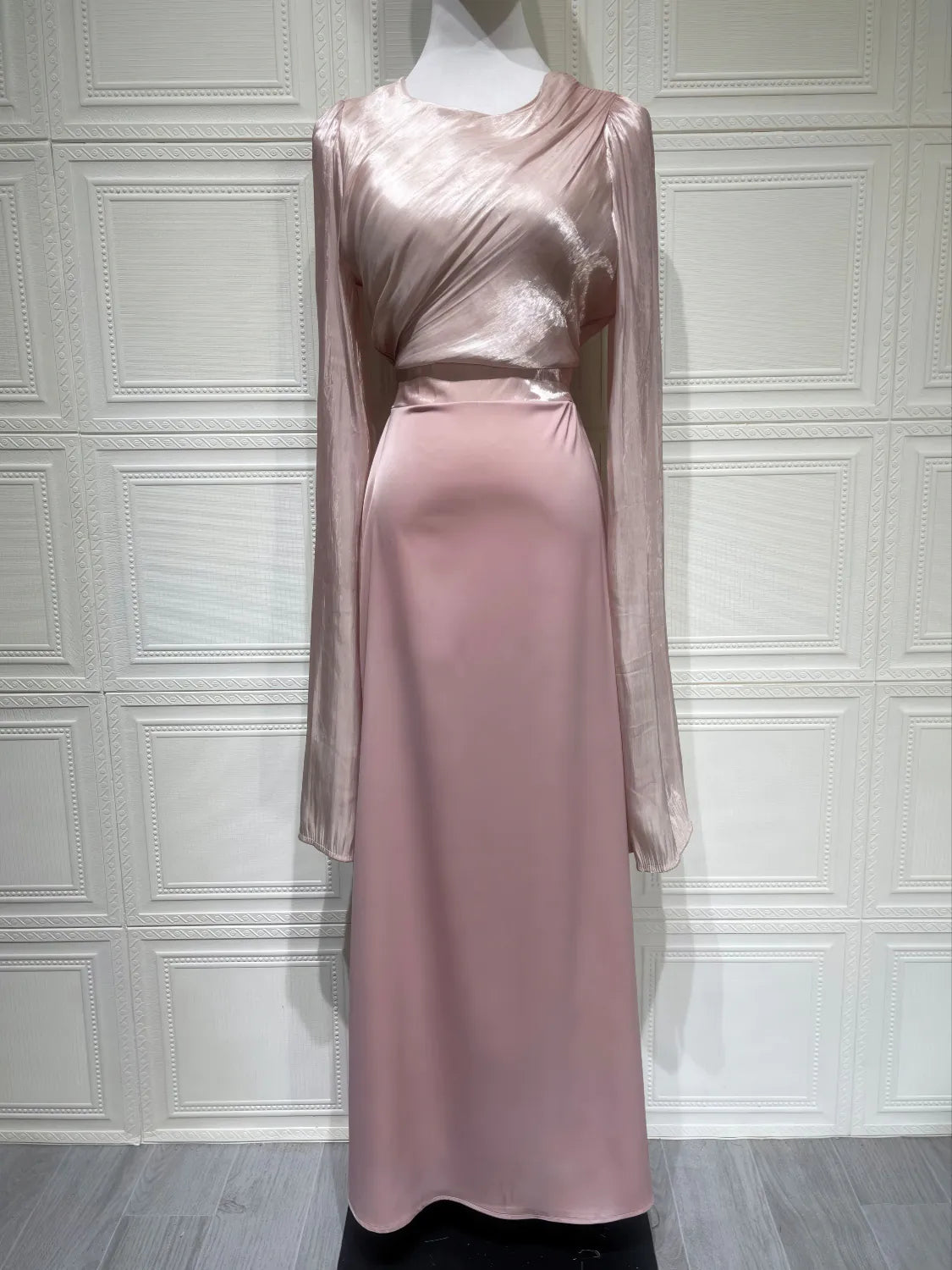 Pink satin dress on a mannequin against a white paneled wall. #Color_Pink