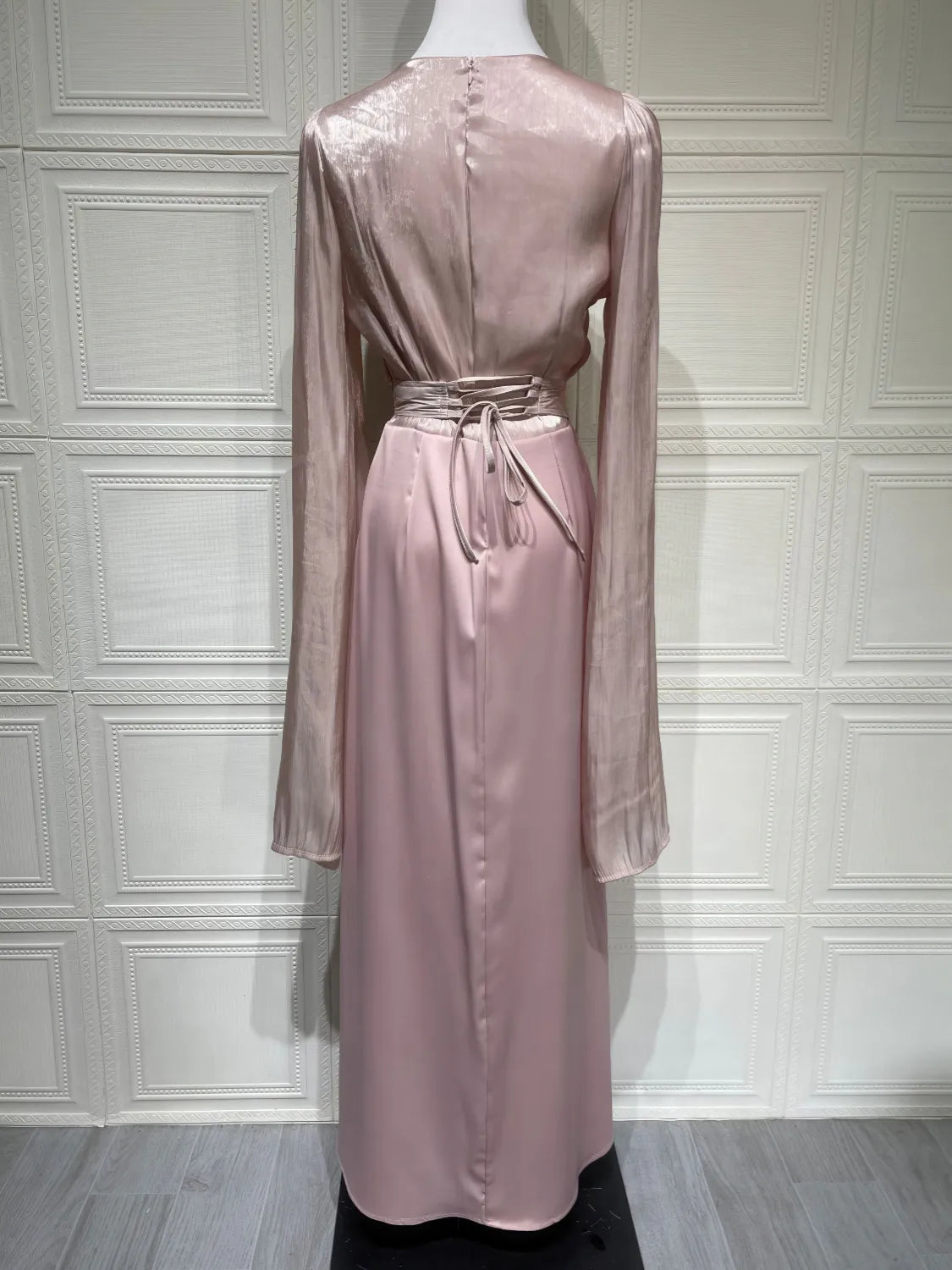 Pink satin dress on a mannequin against a white paneled wall. #Color_Pink