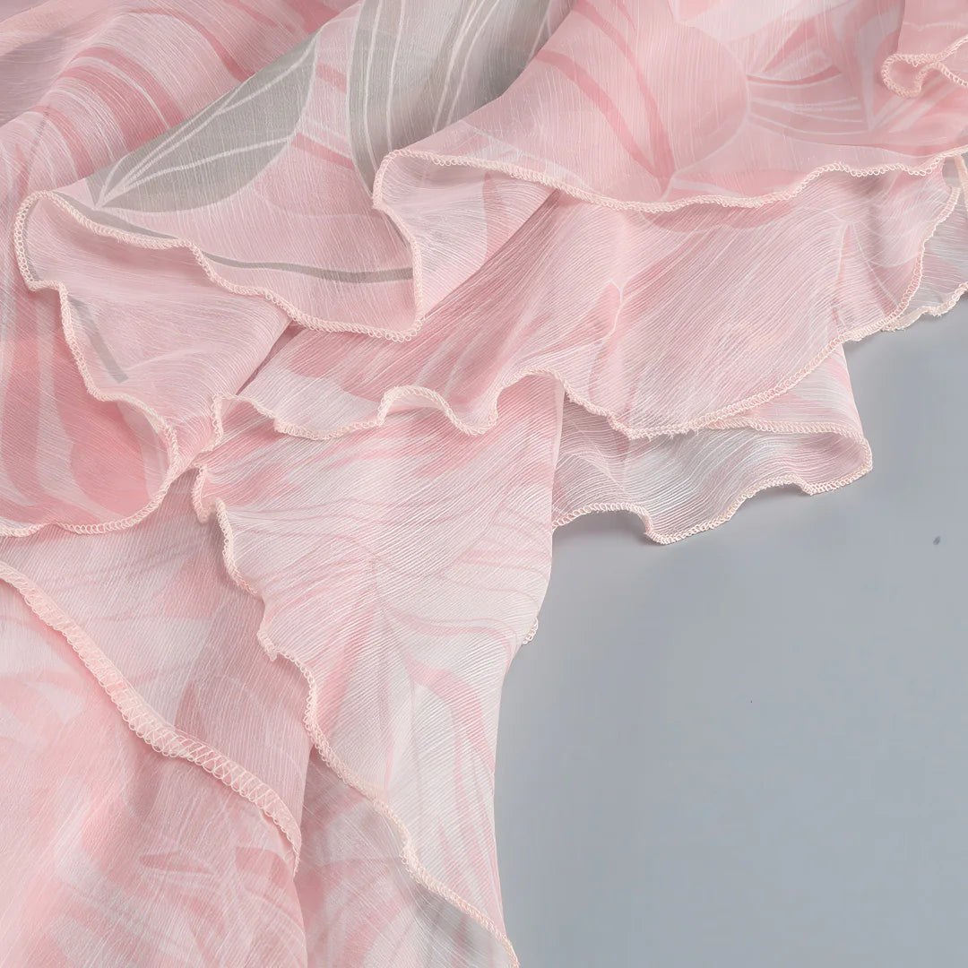 Close-up of a pink floral fabric with ruffled edges on a light gray background