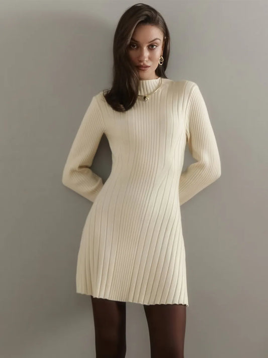 Woman wearing a cream ribbed knit dress against a plain background. #Color_Beige