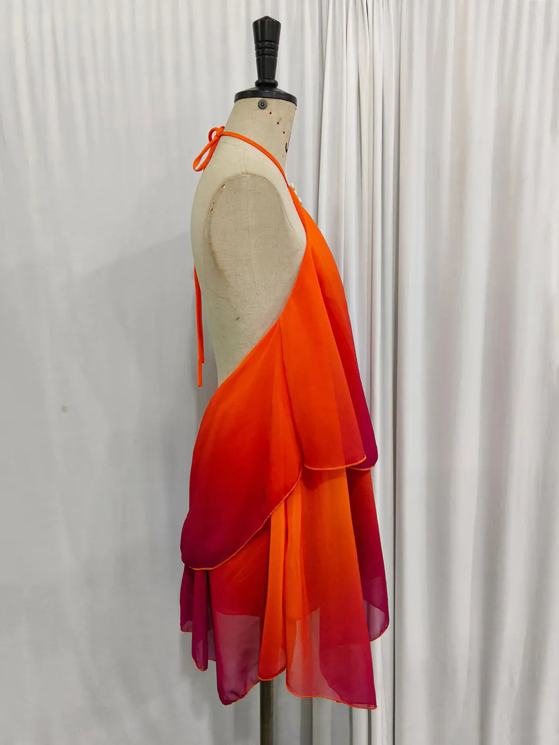 Mannequin wearing a vibrant orange to red gradient dress against a plain background. #Color_OrangeRed