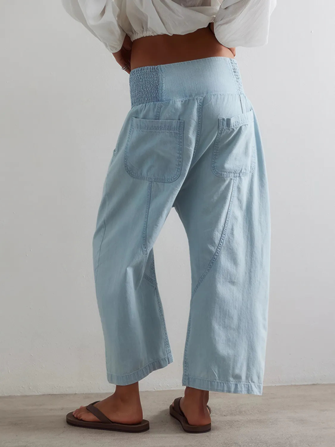 Light blue wide-leg pants worn by a person on a plain background. #Color_LightBlue