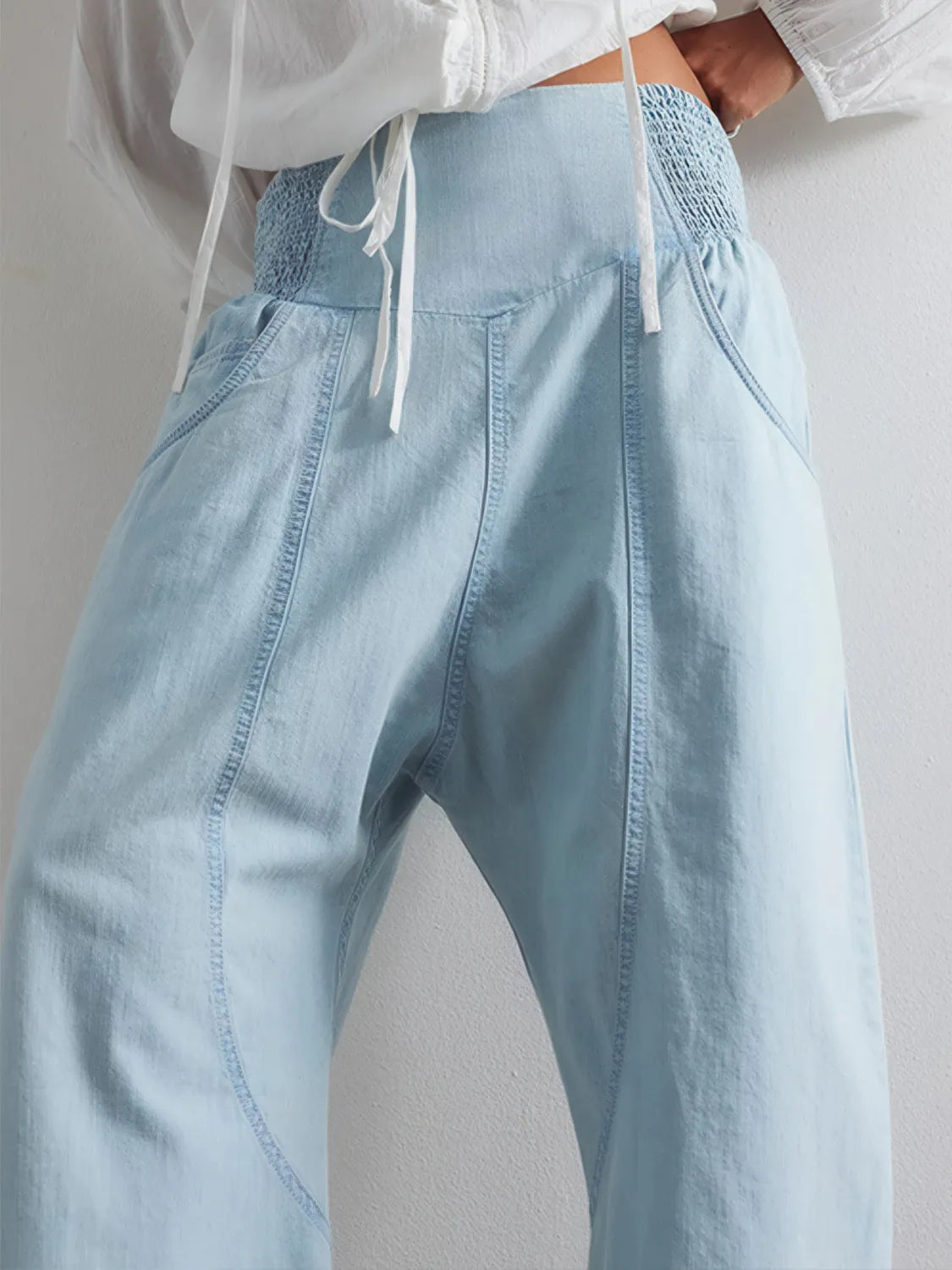 Light blue jeans worn with a white shirt on a plain background. #Color_LightBlue
