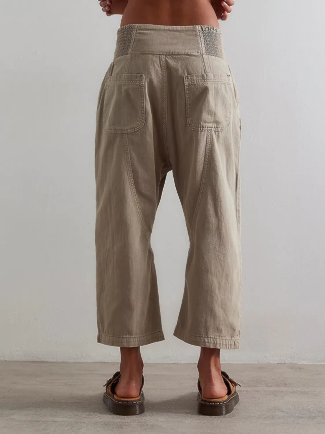Beige wide-leg pants worn by a person on a plain background. #Color_Tan