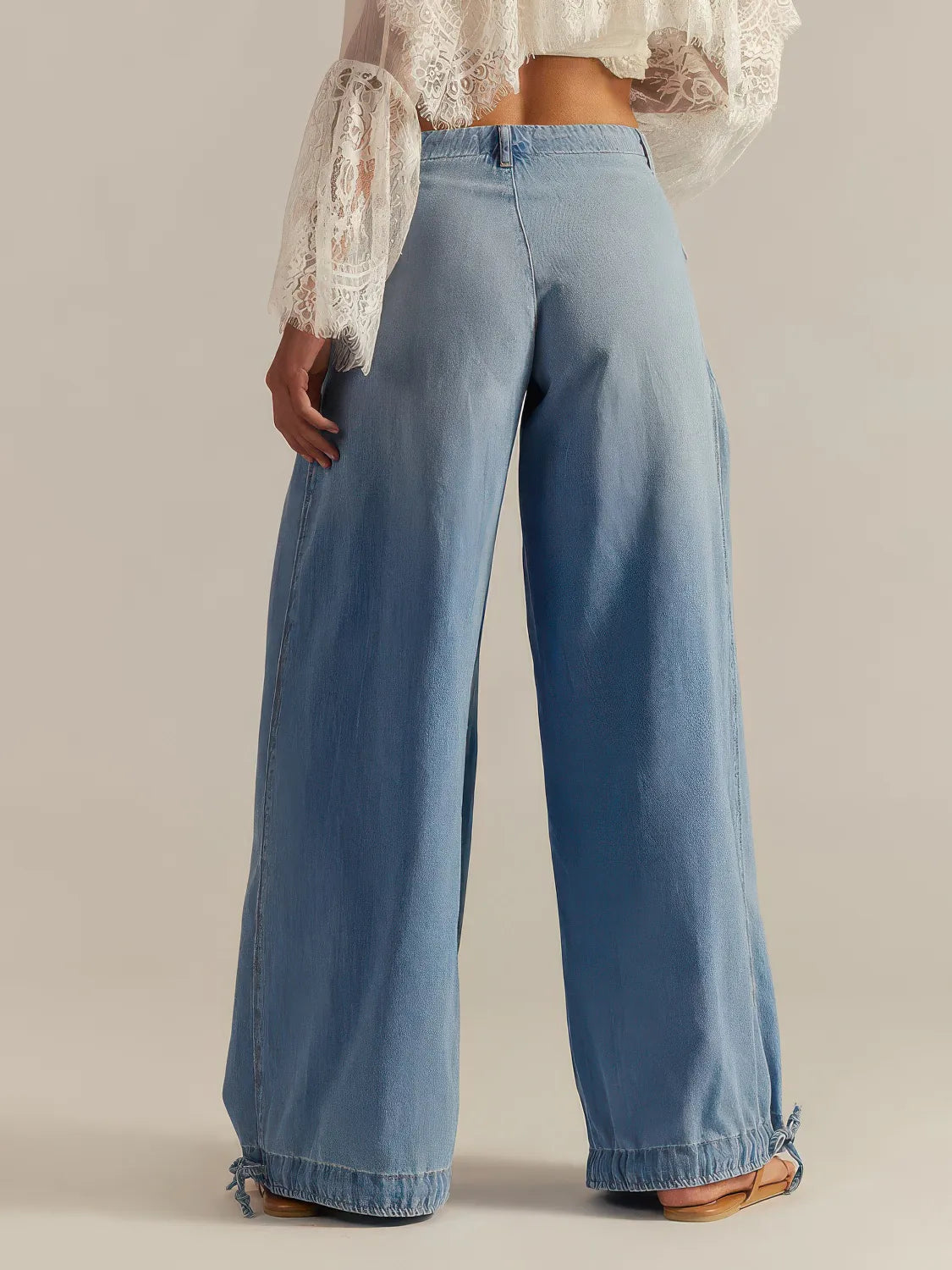 Blue wide-leg jeans worn by a person on a neutral background. #Color_LightBlue