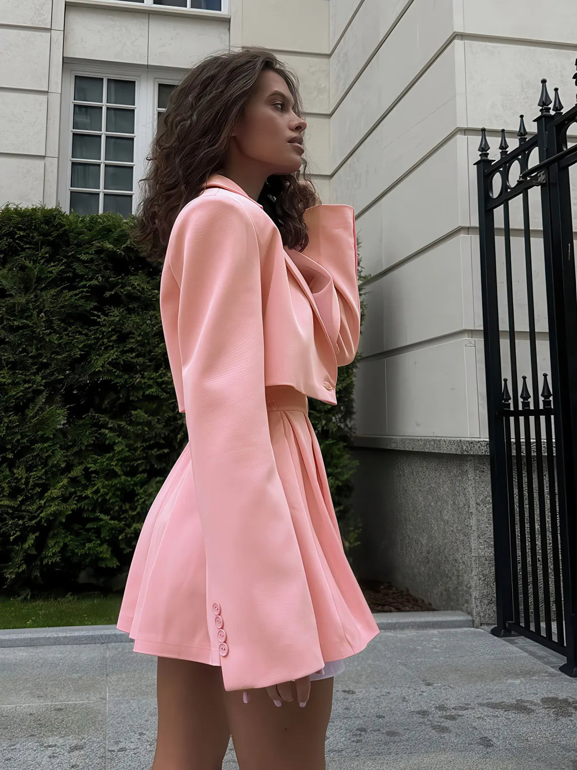 Woman wearing a pink outfit standing in front of a building. #Color_Pink