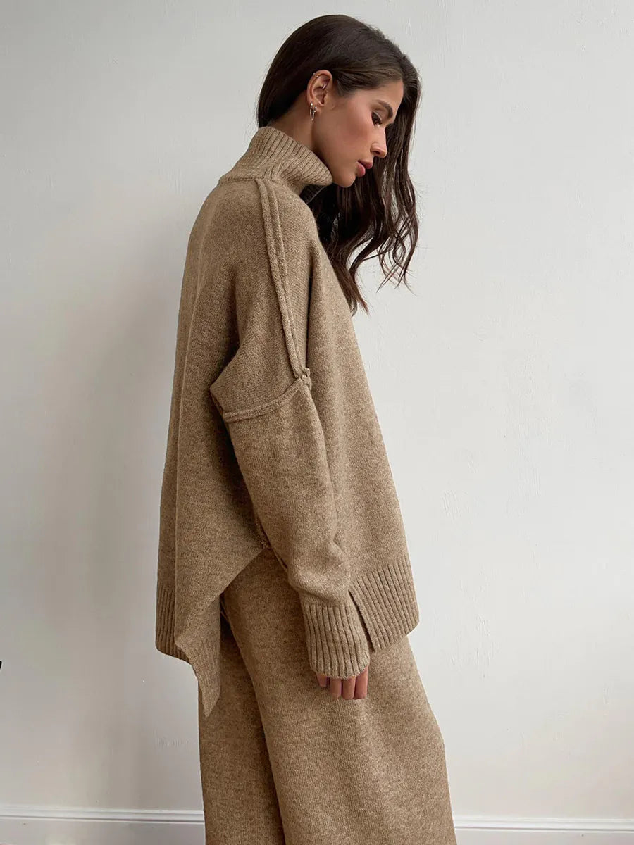 Woman wearing a beige sweater and pants against a plain background. #Color_Tan