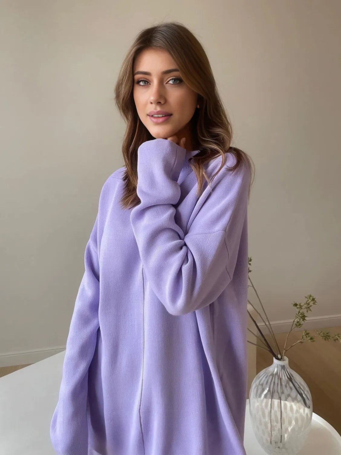 Woman wearing a light purple hoodie in a neutral setting. #Color_Purple