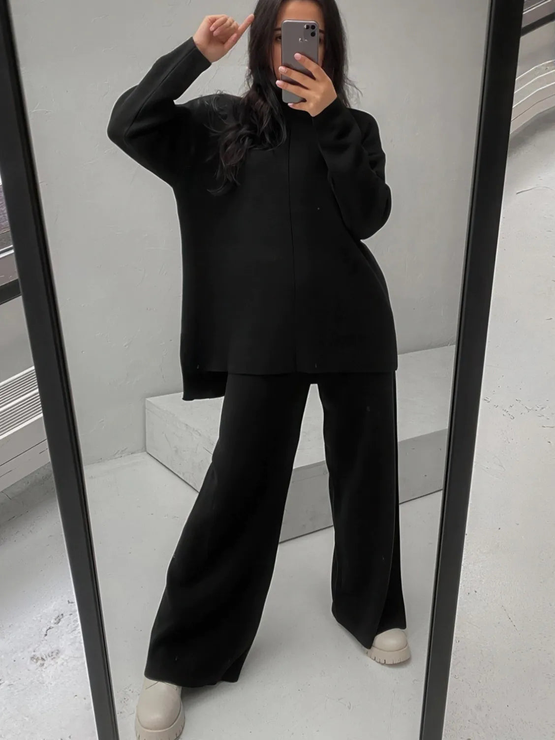 Person wearing a black outfit in front of a mirror. #Color_Black
