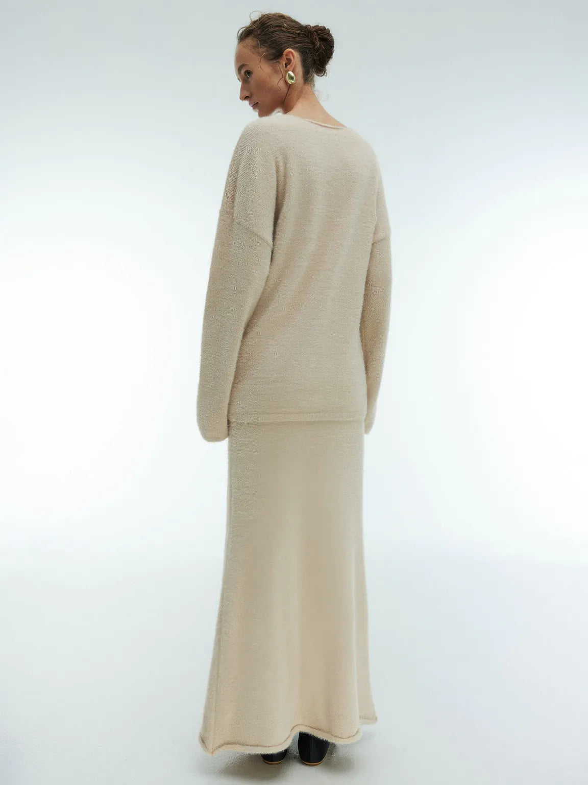 Woman wearing a beige outfit on a white background. #Color_Beige