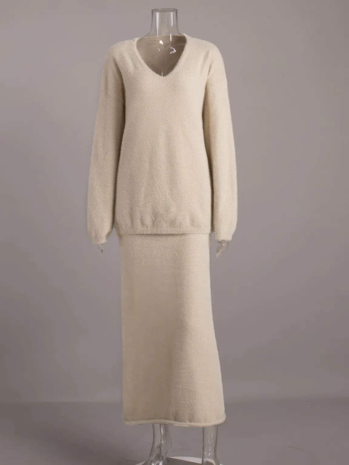 Beige sweater and skirt set on a mannequin against a gray background. #Color_Beige