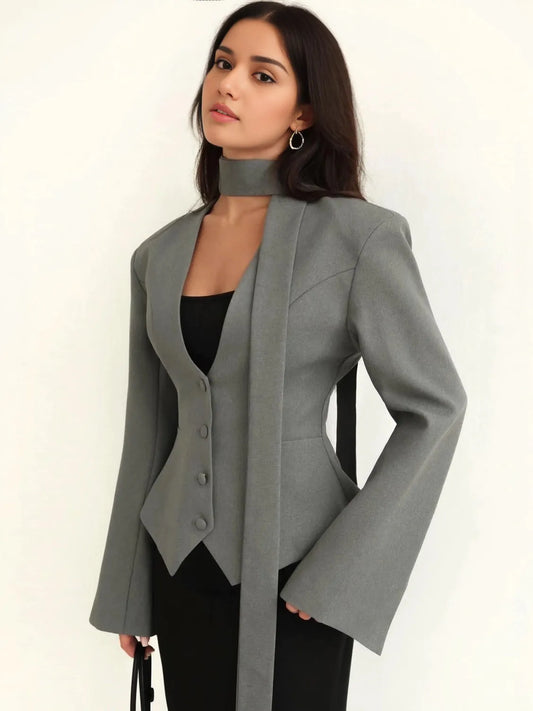 Woman wearing a gray blazer over a black top on a white background. #Color_Gray