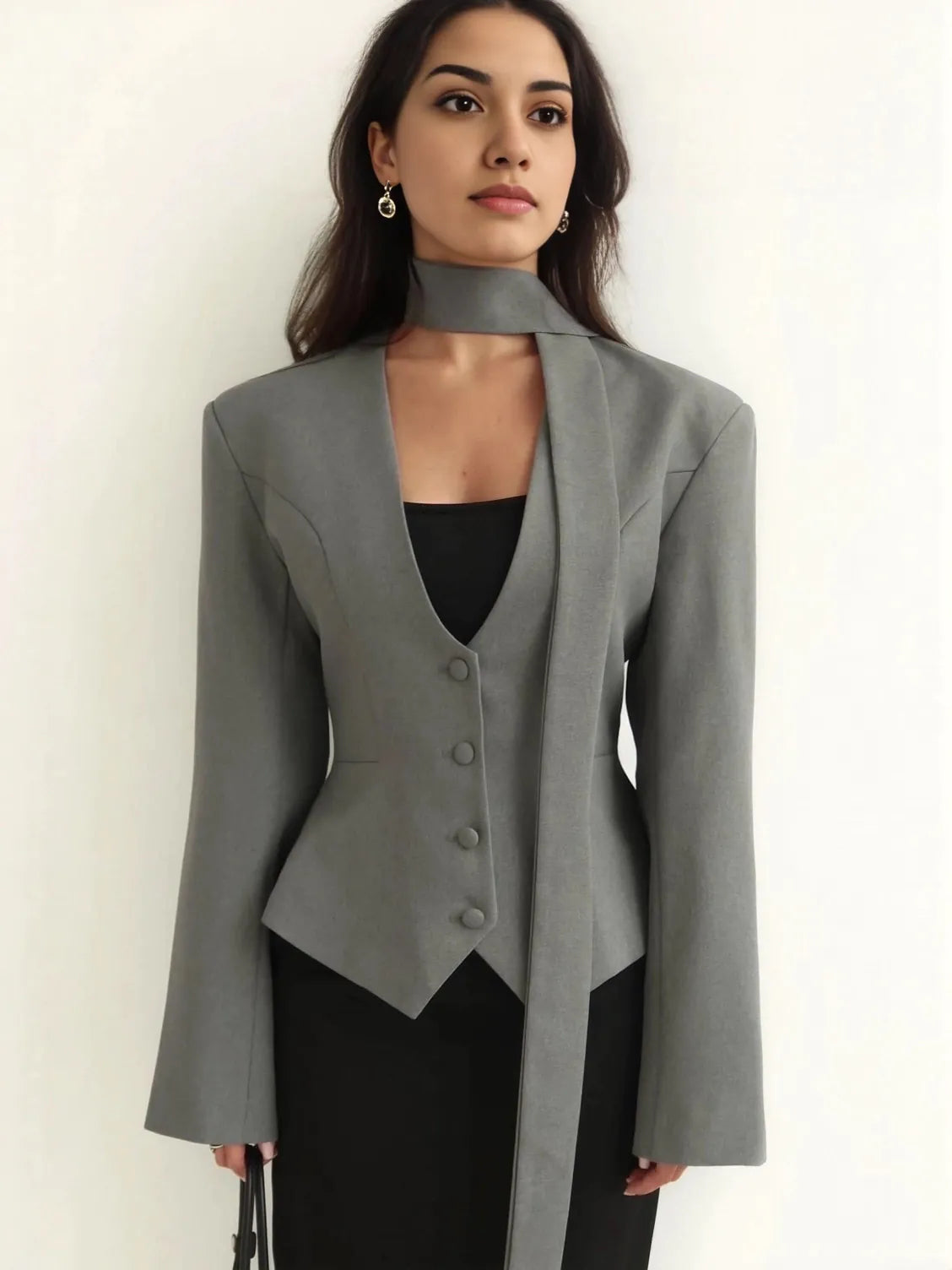 Woman wearing a gray blazer over a black top on a white background. #Color_Gray