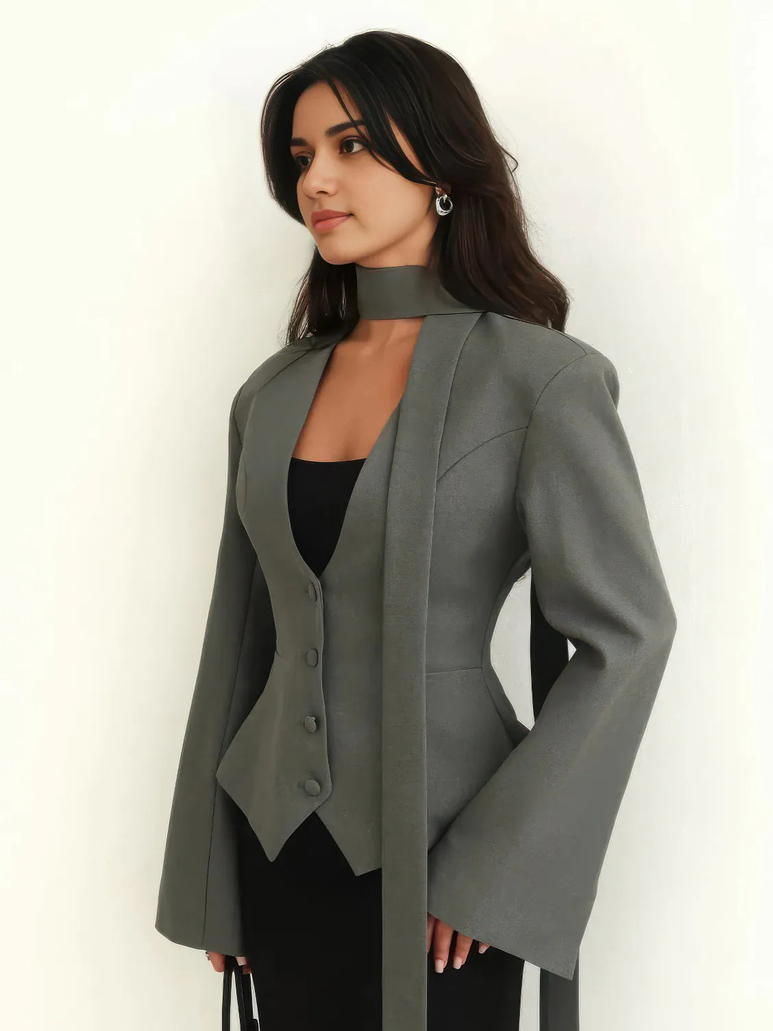 Woman wearing a gray blazer over a black top on a white background. #Color_Gray