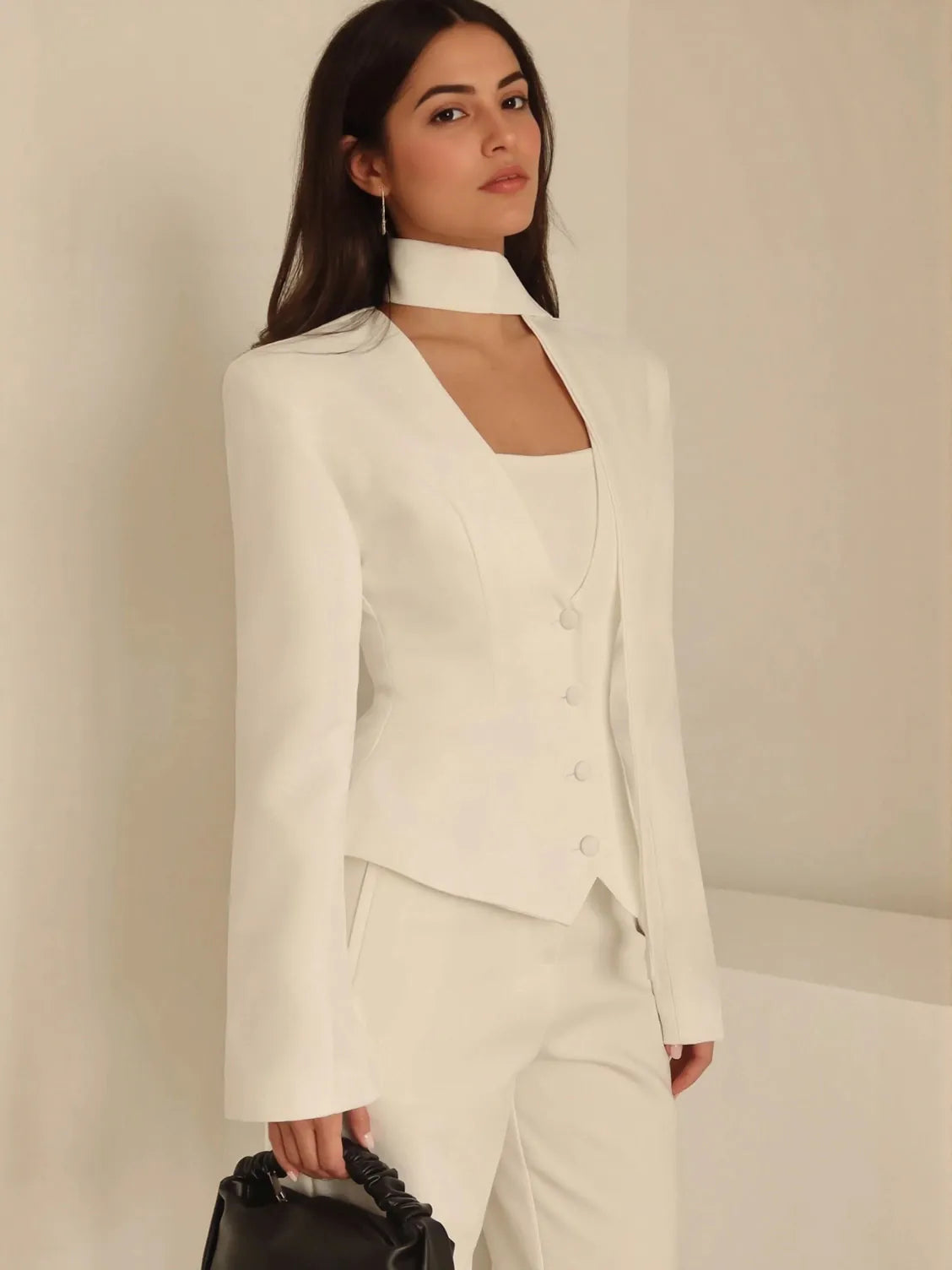 Woman wearing a white suit against a plain background. #Color_White