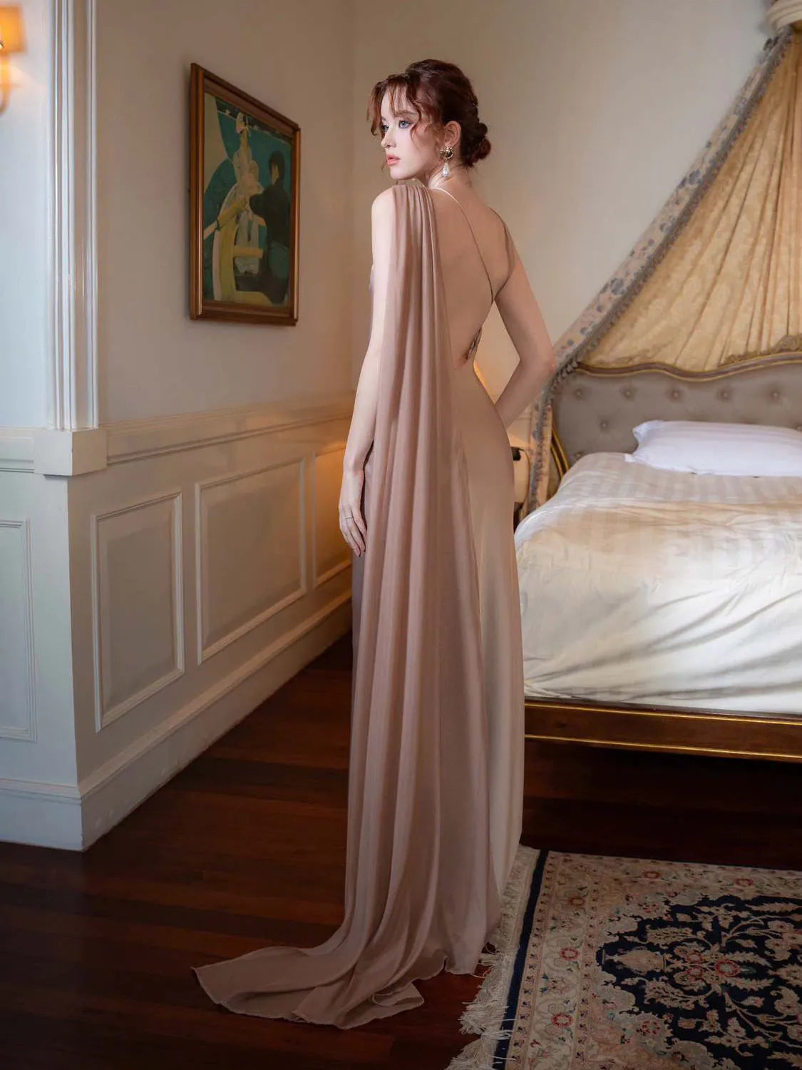Woman in a long, elegant dress standing in a bedroom. #Color_LightGray
